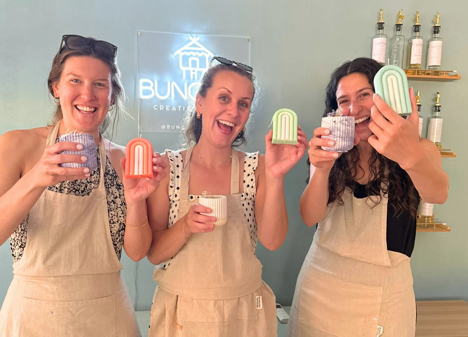Tres chicas brindando con velas artesanales en Bungaló