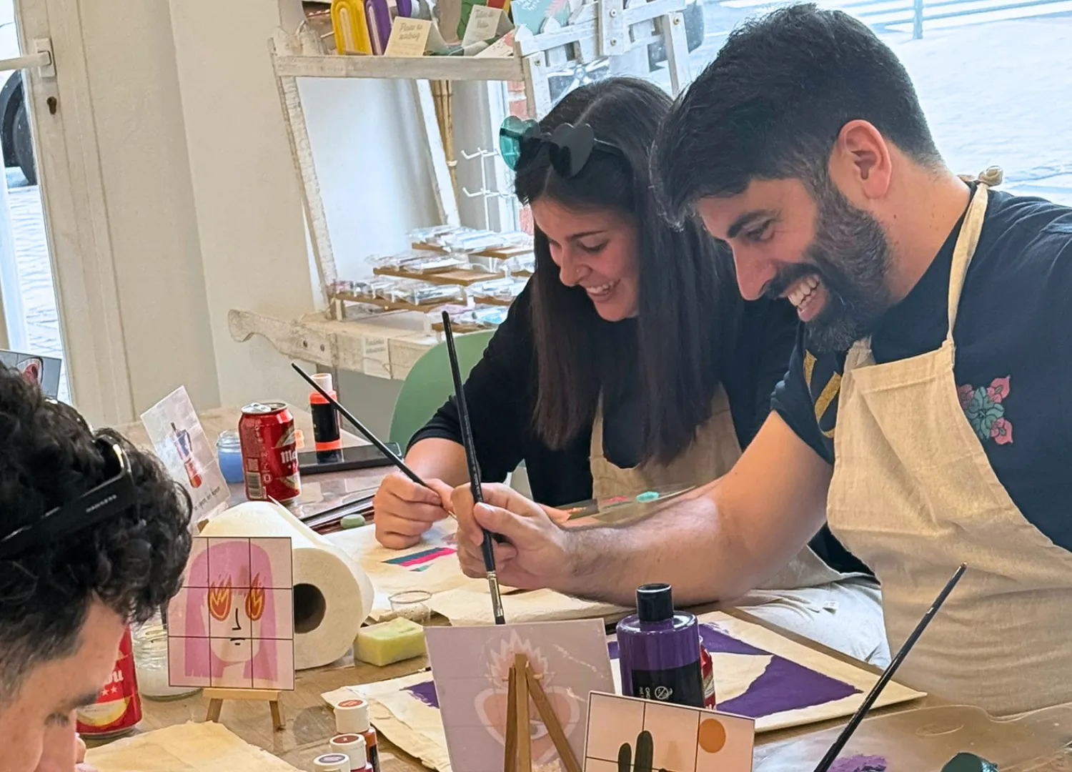 Pareja sonriendo pintando piezas en Bungaló