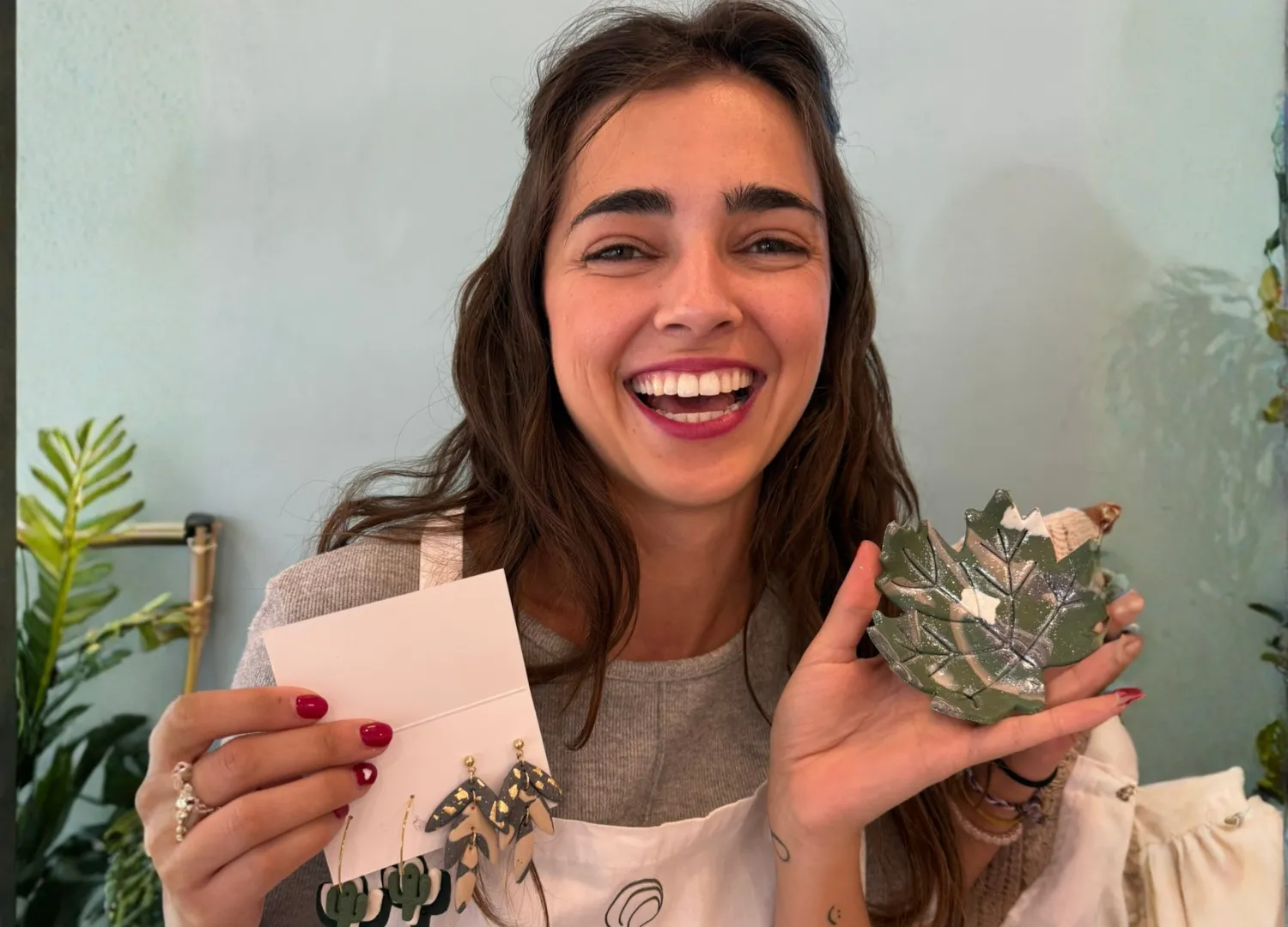 Chica sonriendo con pieza de cerámica y pendientes